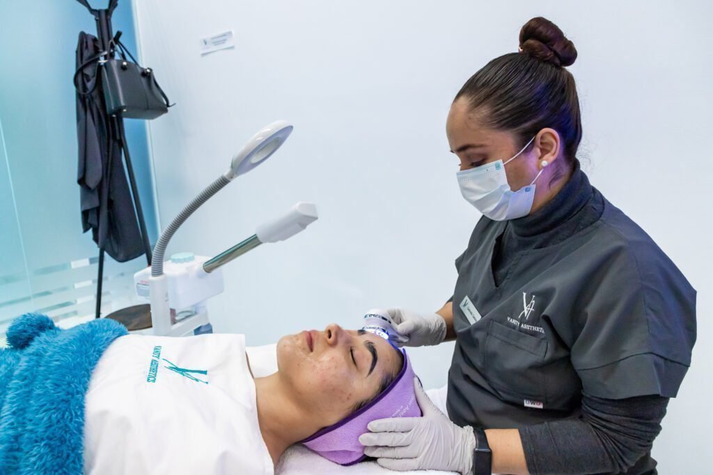 Close-up of a dermatologist using laser treatment to remove a wart on a patient's hand.